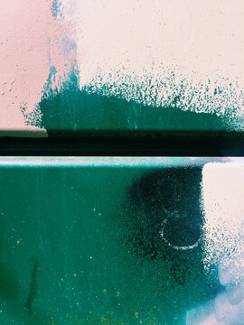 Detail of paint covering graffiti tags on metal wall