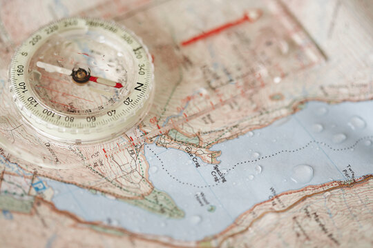 Rain droplets on a waterproof map and compass.