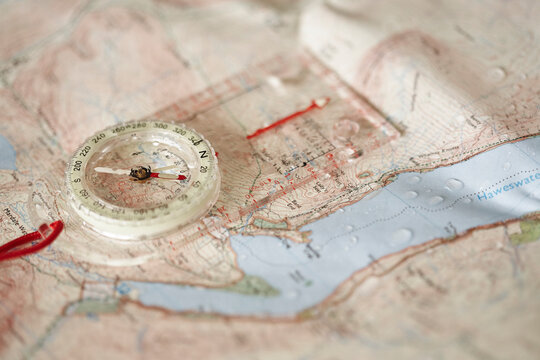 Rain droplets on a waterproof map and compass.