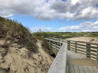 Wooden walkway going through sand dunes.