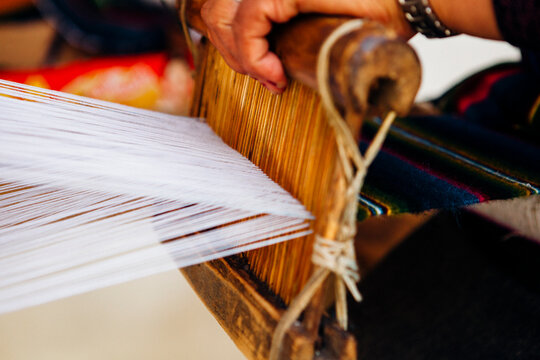Woman's hand making a scarf using traditional ways.