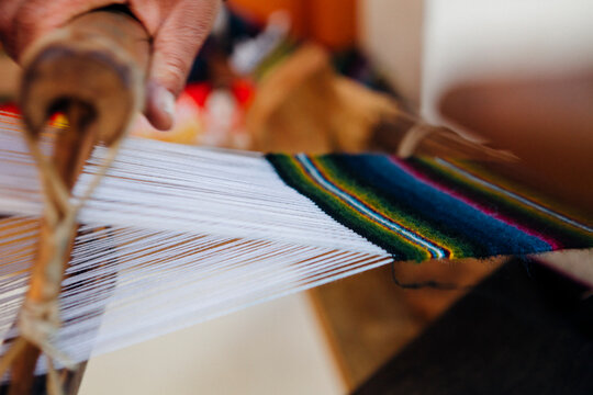 Woman's hand making a scarf using traditional ways.