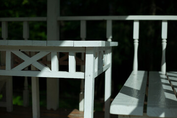 White table and bench on the summer veranda. Wooden furniture. Stylist of the 19th century.