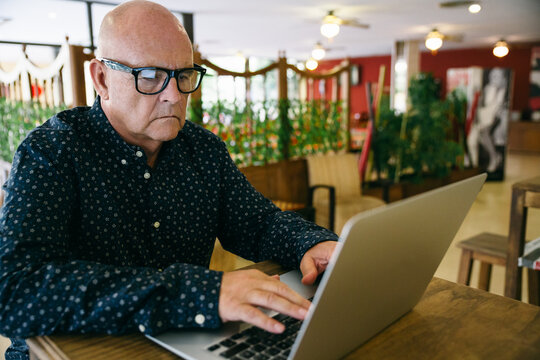 Senior businessman working with his laptop in a cafe restaurant