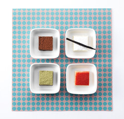 4 colorful chocolates in a cup on a napkin