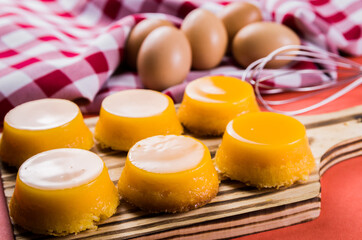 Delicious Quindins on wooden board, traditional Brazilian dessert made with egg yolk, sugar and coconut.