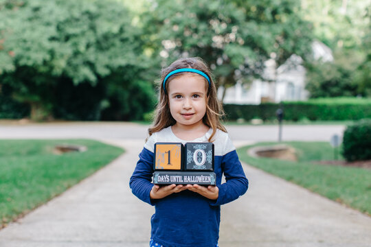 Beautiful young girl holding a countdown sign to halloween