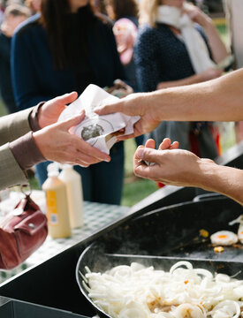 Customer paying market trader for hot food at market stall