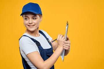 woman in work uniform documents courier service yellow background