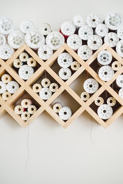 Spools of thread stacked on a grid-based organizer