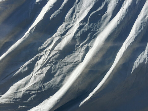 Grey protective fabric covering car, close up