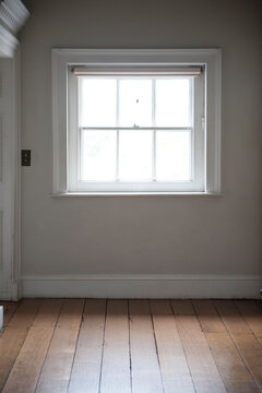 square window empty room interior wooden floorboards and grey wall