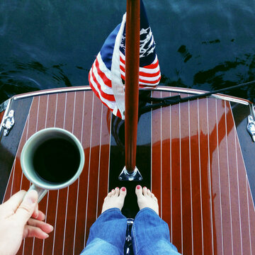 A women enjoys coffee on the back of a wooden boat