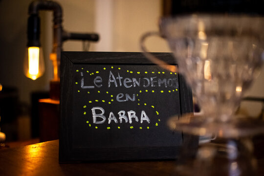 Letrero hecho a mano en café. Le atendemos en barra.