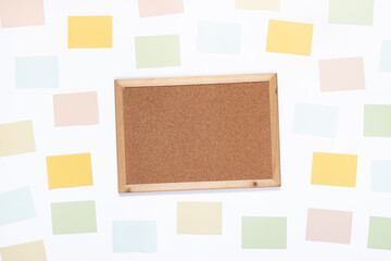 Top view of cork wooden board and paper notes on white background