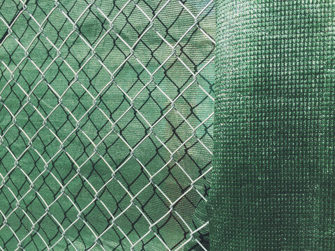 Detail of chain link fence and green fabric at construction site