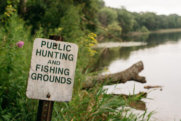 Hunting and fishing groungs public sign by a lake