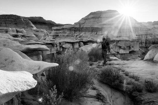 Backpacker Hiking in Bisti De Na Zin Wilderness Area New Mexico at Sunrise Black and White