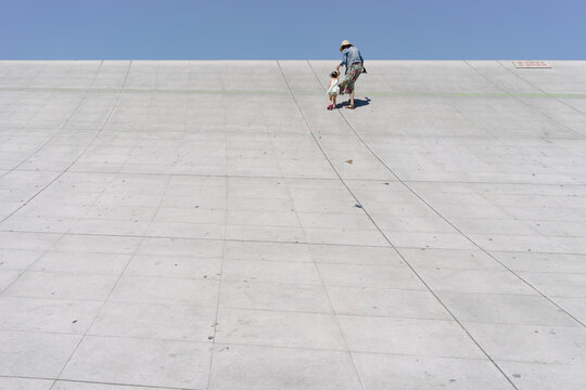 Mother and daughter running on a cement slope