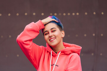 Portrait of a young girl with short colorful hair and nose piercing