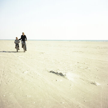 Mother and son cycling on the beach