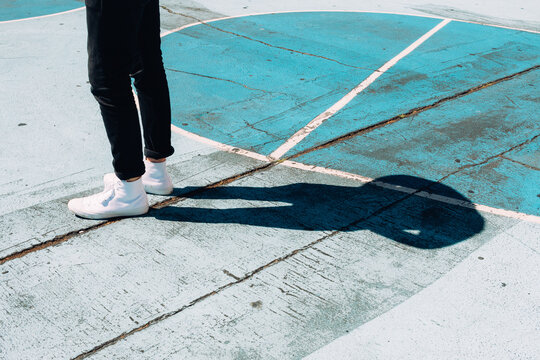 Man Wearing White High Top Converse Standing On Blue Basketball Court