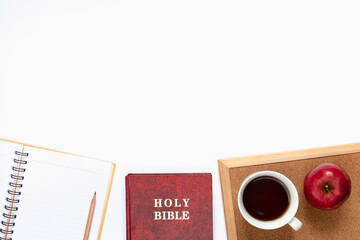 Top view of Bible, notebook, and a cup of coffee on white background