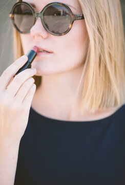 young woman applying red lipstick