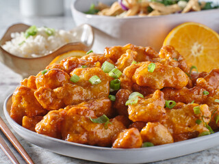 plate of chinese orange chicken with green onion garnish