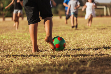 boy kicking soccer ball with feet closeup