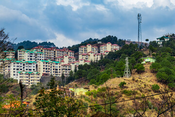 wide shot of buildings along with mountains under the cloudy blue sky