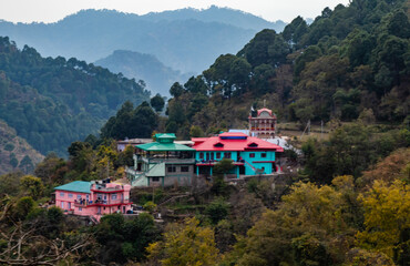 wide shot of colorful houses on a hill with jungle in the background