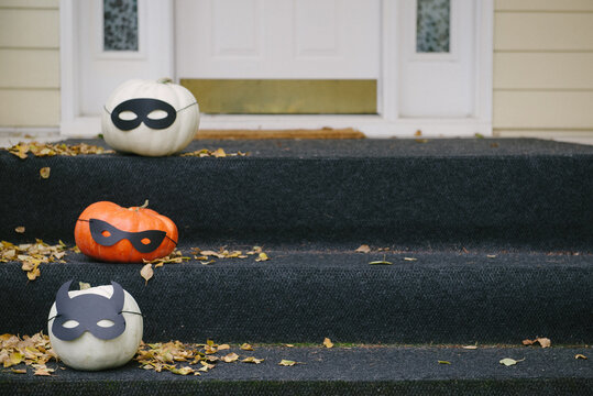 three decorated pumpkins on steps