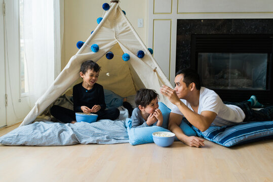 father and two sons throwing popcorn