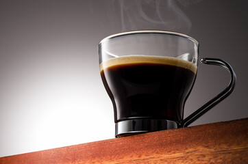 Close up photo of a coffee cup on a Wooden Surface and Gradient Background