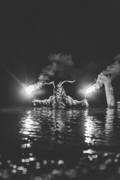 helper to St. Nicholas holding bengal lights in water