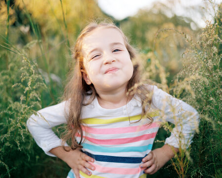 Portrait of a sassy young girl standing in a field of tall grass