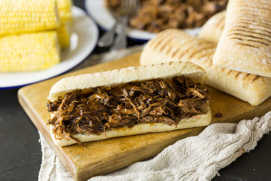 Shredded pulled beef in a panini bread roll sandwich