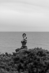 Mujer joven adolescente modelo posando en un acantilado y en la playa. Chica vestida elegante para modelo