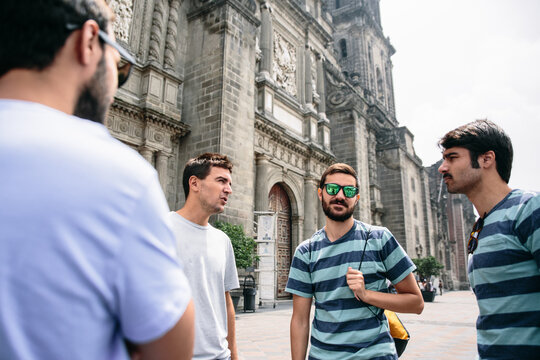 Group of friends talking in front of a cathedral facade in Mexico
