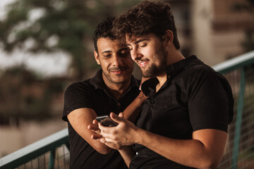 gay couple talking and having fun with cellphone