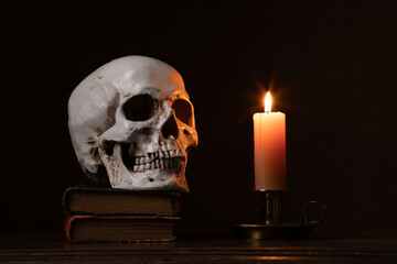 Still life type a scene with human skull and candle