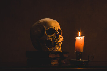 Still life type a scene with human skull and candle