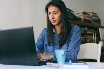 Beautiful woman working on a laptop in her home