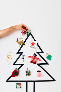 Male Hand Putting Mistletoe on a Top of the Christmas Tree