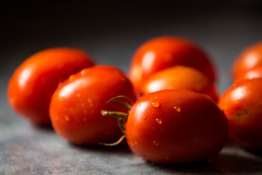 Closeup image of fresh, wet, red vine tomatoes on a countertop