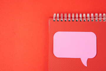 Notepad with pink sticky note on red background top view Copy Space