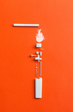 White disassembled lighter with cigarette on orange/red background