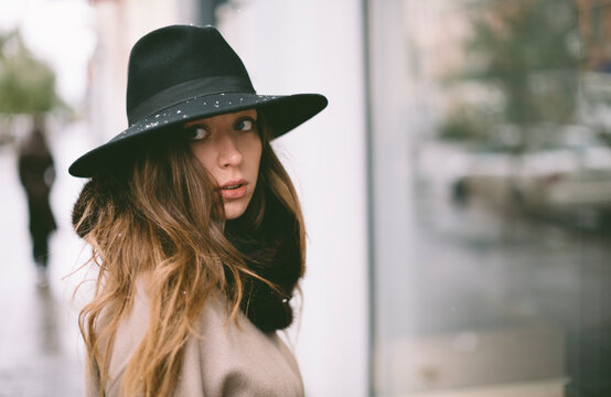 winter portrait of young woman with hat on the street