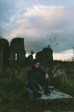 Man Sitting on a Grave in the Cemitery